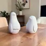Atölye Kiraz dekoratif biblo ve heykel kategorisinde yer alan AYB070 stok kodlu dekoratif ikili penguen heykeli modelinin, arka planda pembe bahar çiçeklerinin yer aldığı ahşap yüzey üzerinde, sağ ve sol figür simetrisini tam karşıdan gösteren net katalog görselidir.