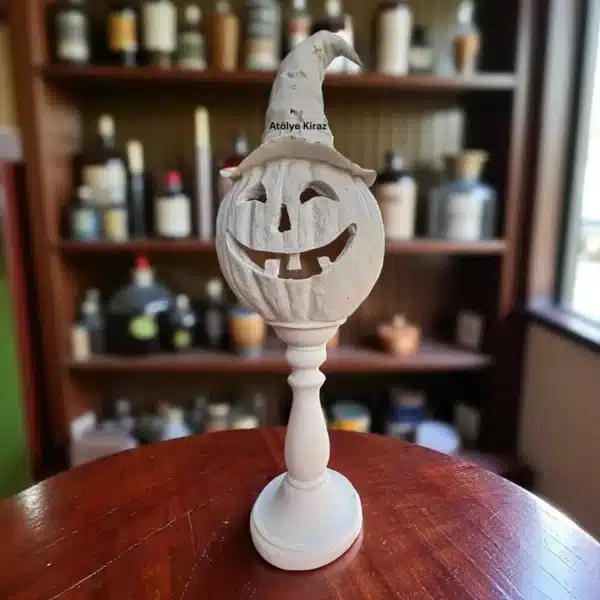 Koyu Renk Ahşap Bir Masada, Arkasında Kitaplık Ve Şişeler Olan Bir Ortamda Sergilenen Cadı Şapkalı Ham Polyester Kabak Heykeli. Otantik Halloween Ev Dekoru.